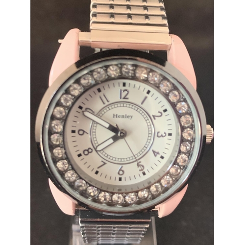 609 - A HENLEYS FASHION WRIST WATCH WITH PINK CASE AND CLEAR STONE DIAL DECORATION IN WORKING ORDER