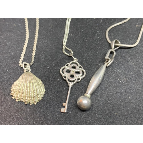 649 - THREE SILVER NECKLACES WITH PENDANTS TO INCLUDE A SHELL, KEY AND DROP