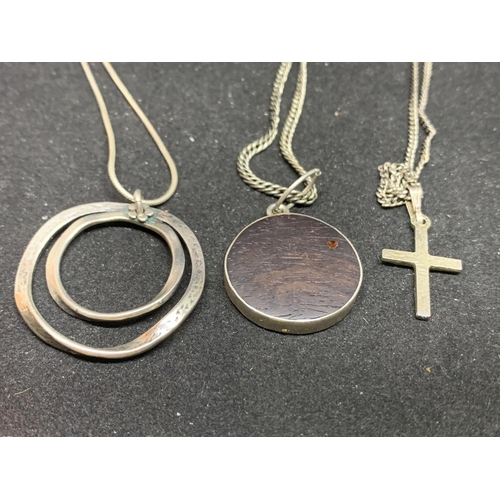 651 - THREE SILVER NECKLACES WITH PENDANTS TO INCLUDE A CROSSAND CIRCLES