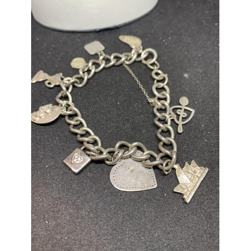 657 - A SILVER CHARM BRACELET WITH NINE CHARMS WITH A PRESENTATION BOX