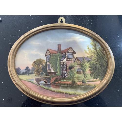 719 - A FRAMED OVAL CERAMIC PLAQUE OF LITTLE MORETON HALL BY JOHN THORLEY