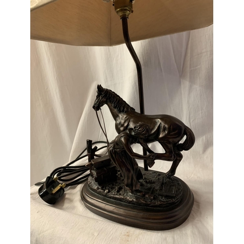 40 - A HIGHLY DECORATIVE TABLE LAMP IN THE FORM OF A HORSE AND BLACKSMITH AT WORK H: TO BULB BASE 38CM