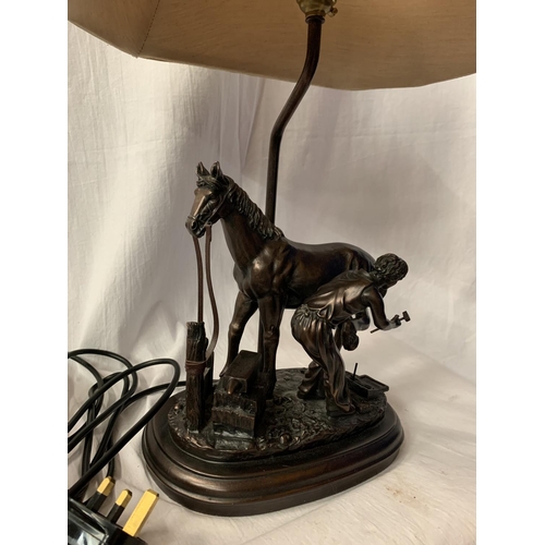 40 - A HIGHLY DECORATIVE TABLE LAMP IN THE FORM OF A HORSE AND BLACKSMITH AT WORK H: TO BULB BASE 38CM