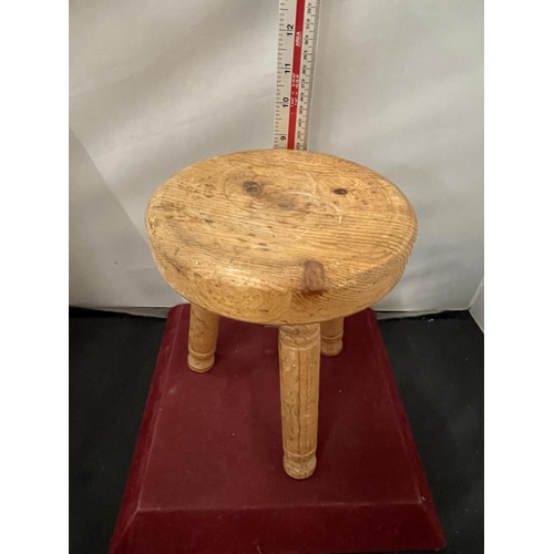 122 - A SMALL WOODEN THREE LEGGED MILKING STOOL H- 22CM DIA -18CM