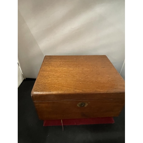 128 - AN EARLY WOODEN WRITING SLOPE WITH RED VELVET SLOPE, TWO GLASS INK POTS AND DRAWER TO SIDE