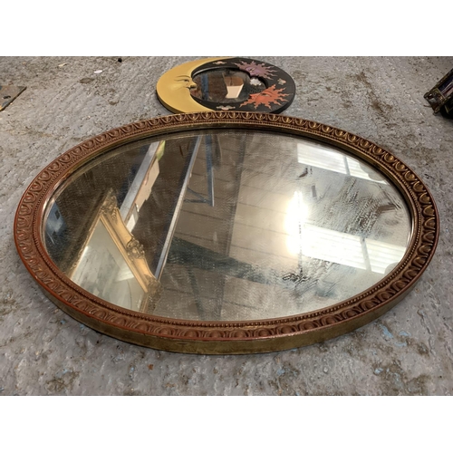 195 - AN ORNATE GILT OVAL FRAMED MIRROR AND ANOTHER WITH MOON FACES