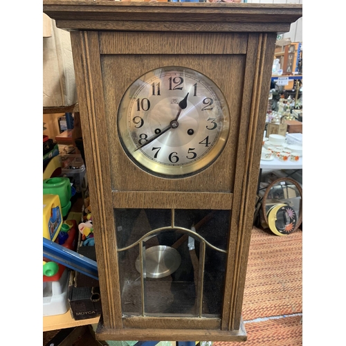 208 - A VINTAGE WOODEN WALL CLOCK WITH BRASS AND GLASS DETAIL IN THE DOOR H:61CM