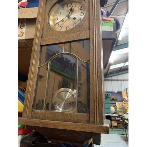 208 - A VINTAGE WOODEN WALL CLOCK WITH BRASS AND GLASS DETAIL IN THE DOOR H:61CM