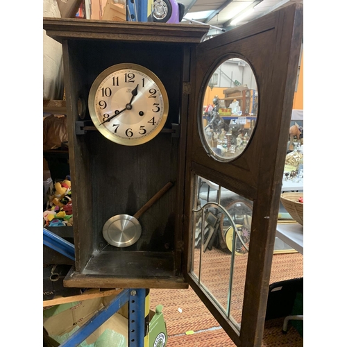 208 - A VINTAGE WOODEN WALL CLOCK WITH BRASS AND GLASS DETAIL IN THE DOOR H:61CM