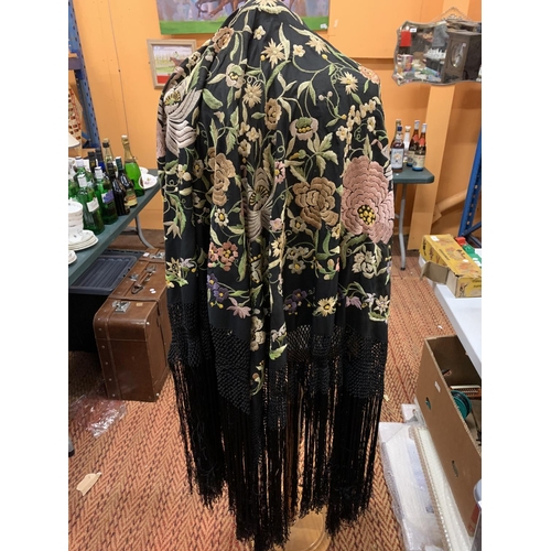 213 - A LARGE SILK EMBROIDERED BLACK TASSELLED SHAWL