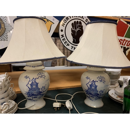 216 - A PAIR OF CERAMIC BASED BLUE AND WHITE TABLE LAMPS COMPLETE WITH SHADES H: TO BOTTOM OF BULB 37CM AP... 