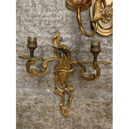 231 - A PAIR OF ORNATE METAL GILT TWIN WALL LIGHTS AND A SINGLE METAL TWIN WALL LIGHT WITH LION'S HEAD DEC... 