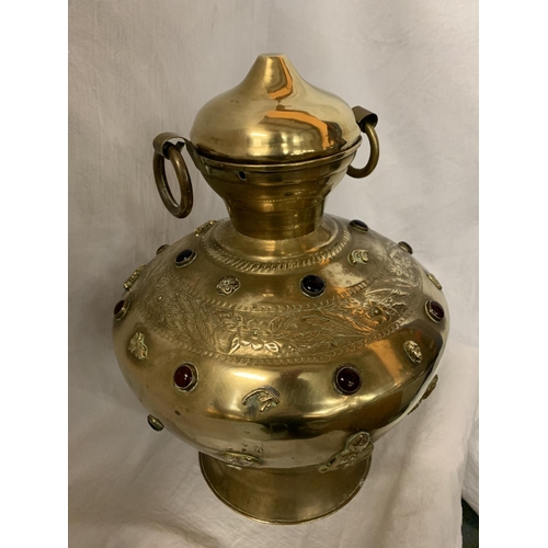50 - A LARGE BRASS TWIN HANDLED AND LIDDED URN WITH RED STONE DECORATIVE DETAIL H:APPROX. 35CM