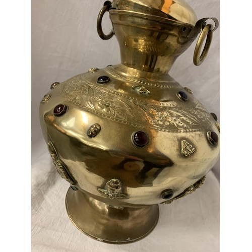 50 - A LARGE BRASS TWIN HANDLED AND LIDDED URN WITH RED STONE DECORATIVE DETAIL H:APPROX. 35CM