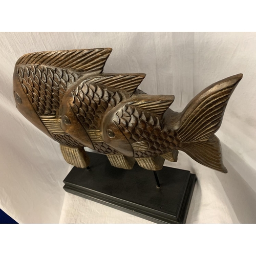 56 - A VERY LARGE HARD WOOD FISH MOUNTED ON A PLINTH OF THE SAME H: APPROX. 45CM