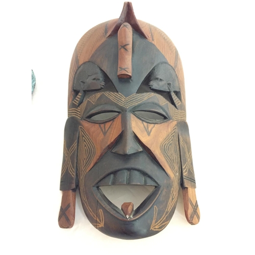 165 - A HARDWOOD CARVED TRIBAL MASK AND A GREEK CERAMIC MASK OF ZEUS