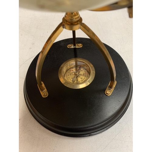 32 - A DECORATIVE DESK GLOBE WITH BRASS DETAIL AND INTEGRATED COMPASS IN THE BASE H: APPROXIMATELY 31CM