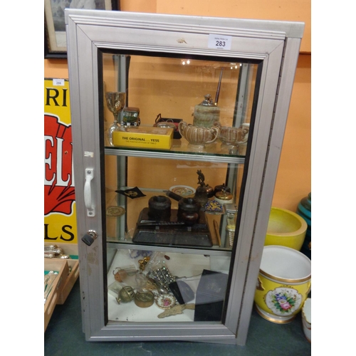 283 - A METAL DISPLAY UNIT WITH KEY ENCLOSING TWO GLASS SHELVES TO INCLUDE THE CONTENTS OF AN ONYX TABLE L... 