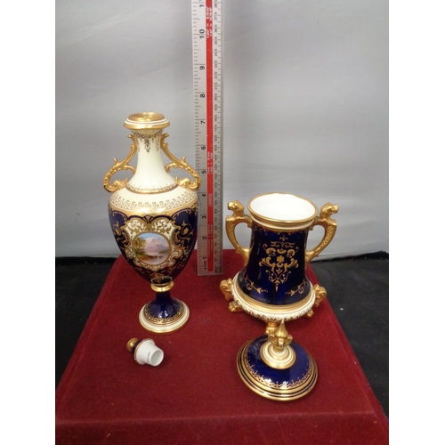 752 - TWO ORNATE LIDDED URNS WITH DARK BLUE AND GILT DECORATION A/F HAIRLINE CRACK ON SMALLER URN