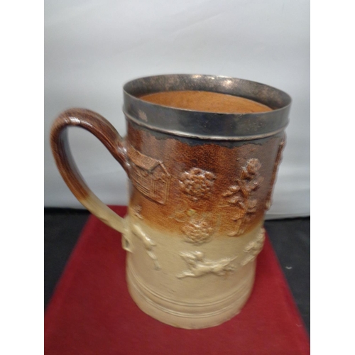 757 - A VERY LARGE LAMBETH WARE TANKARD INSCRIBED MILLFORD 1735 WITH A WHITE METAL PROBABLY SILVER RIM