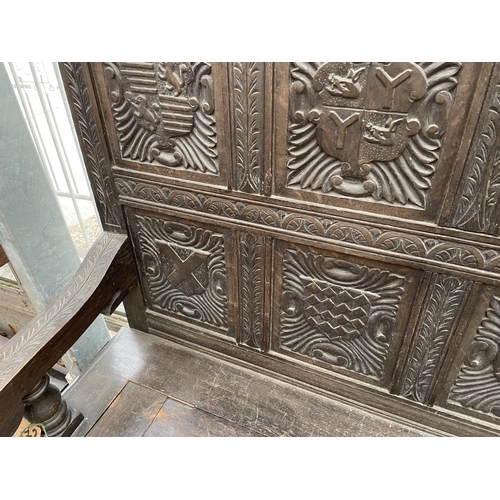 2006 - A VICTORIAN OAK SETTLE WITH TWELVE CARVED PANELS DEPICTING VARIOUS CRESTS AND MOTTO 'EAST, WEST, HOM... 