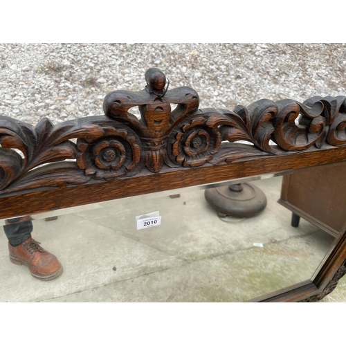 2010 - A HEAVILY CARVED OAK JACOBEAN STYLE WALL MIRROR WITH BEVEL EDGE, 51