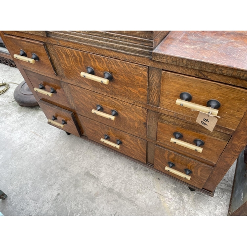 2012 - AN EARLY 20TH CENTURY OAK DRESSING CHEST ENCLOSING NINE DRAWERS