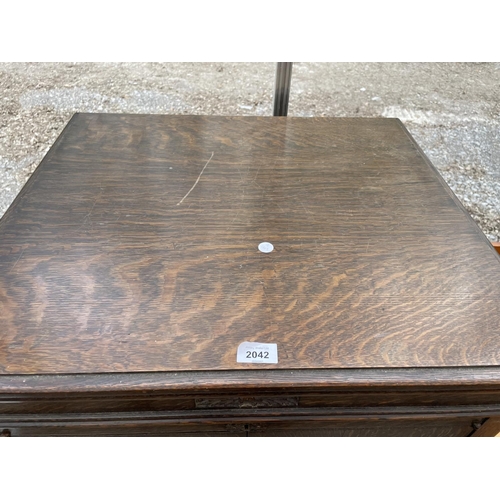 2042 - AN EARLY 20TH CENTURY OAK TWO DOOR CABINET ON OPEN BASE WITH TURNED LEGS, 24