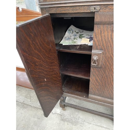 2042 - AN EARLY 20TH CENTURY OAK TWO DOOR CABINET ON OPEN BASE WITH TURNED LEGS, 24