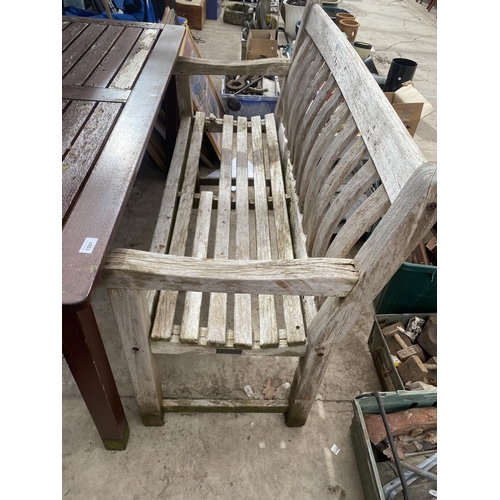 1597 - A RECTANGULAR TEAK TABLE AND A WOODEN SLATTED GARDEN BENCH