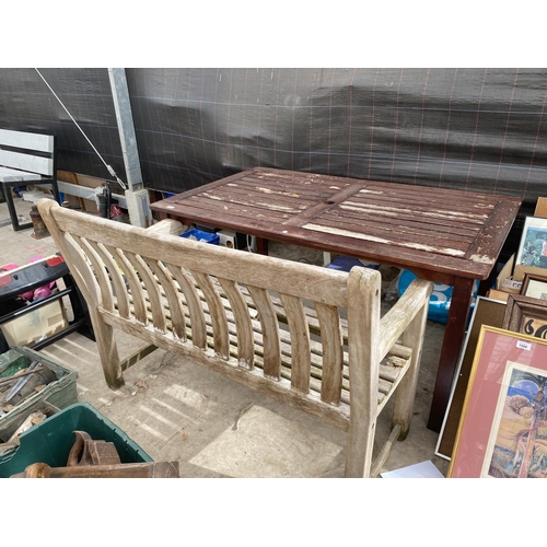 1597 - A RECTANGULAR TEAK TABLE AND A WOODEN SLATTED GARDEN BENCH