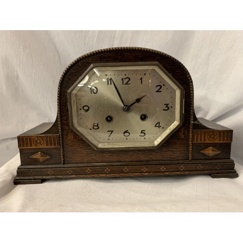 102 - A NAPOLEON'S HAT MAHOGANY MANTEL CLOCK WITH OCTAGONAL FACE AND DECORATIVE EDGING