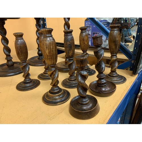 127 - A SELECTION OF ELEVEN WOODEN CANDLESTICKS OF VARIOUS SIZES THE TALLEST BEING 68CM HIGH AND THE SHORT... 