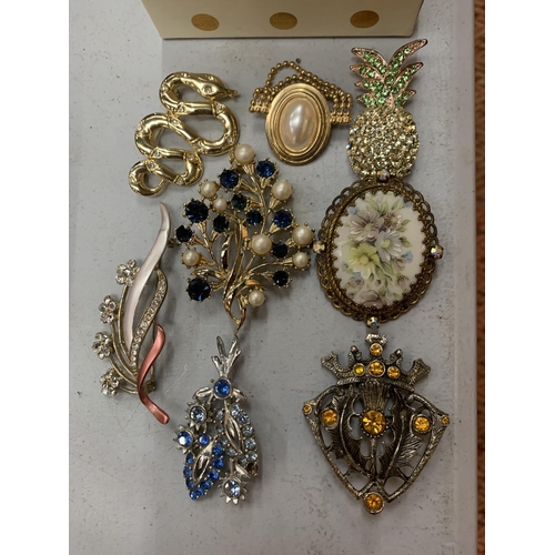 224 - A SMALL BOX OF COSTUME BROOCHES