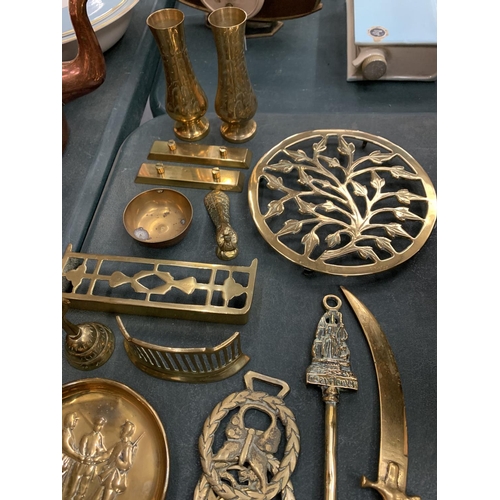 82 - A LARGE QUANTITY OF BRASS AND COPPER WARE TO INCLUDE KETTLES, DISHES, A BRASS DECORATIVE OVAL HINGE ... 