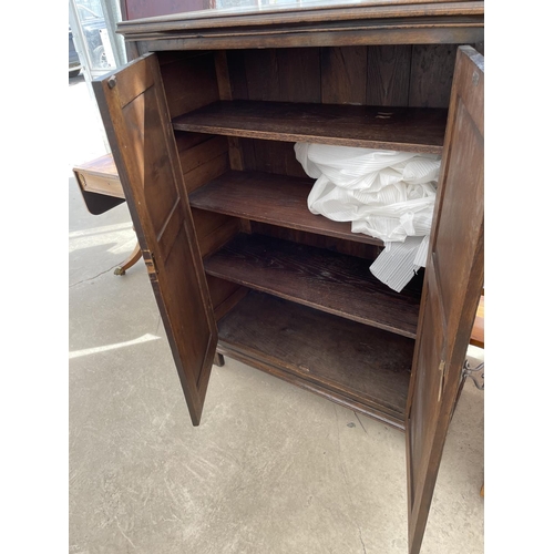 2099 - A REPRODUCTION OAK TWO DOOR CABINET WITH LINENFOLD DOORS 'GOODALLS FURNISHERS' MANCHESTER, 41.5