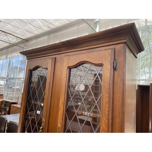 2142 - A MODERN TWO DOOR BOOKCASE ON BASE, WITH GLAZED LEADED UPPER PORTION AND CUPBOARDS BELOW, 40