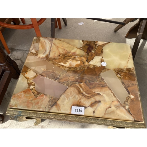 2189 - A MODERN BRASS FRAMED LOW TABLE WITH INSET RESIN TOP INCORPORATING DECORATIVE STONES, 17X13