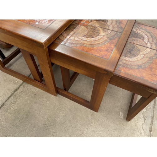 2203 - A RETRO TEAK FRAMED NEST OF THREE TABLES WITH INSET TILED TOP