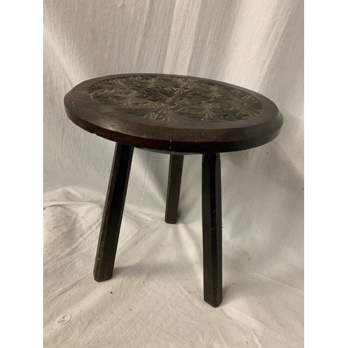 38A - A SMALL THREE LEGGED HARD WOOD STOOL WITH CARVING TO THE SEAT H: 28.5CM