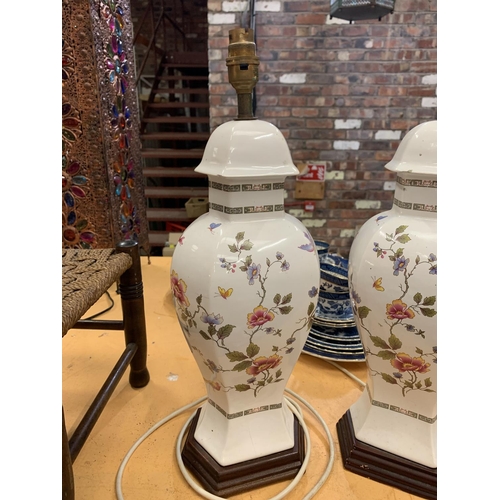 392 - A PAIR OF DECORATIVE CERAMIC TABLE LAMPS WITH A FLORAL DESIGN (A/F - HAIRLINE CRACK)