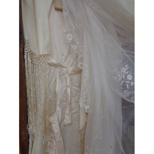 875 - A VINTAGE SATIN WEDDING GOWN, A SILK FRINGED WEDDING SHAWL, TWO LACE VEILS, A VINTAGE BEADED BAG AND... 