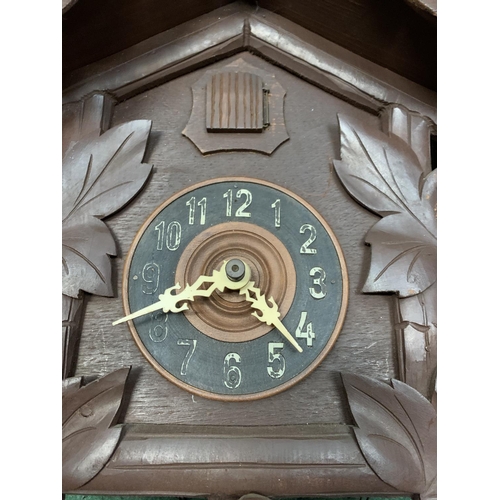 60 - A DECORATIVE WOODEN CUCKOO CLOCK WITH WEIGHTS