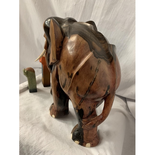 67 - A LARGE CARVED HEAVY HARD WOOD ELEPHANT (H: APPROX. 30CM) AND TWO CERAMIC ELEPHANT ITEMS