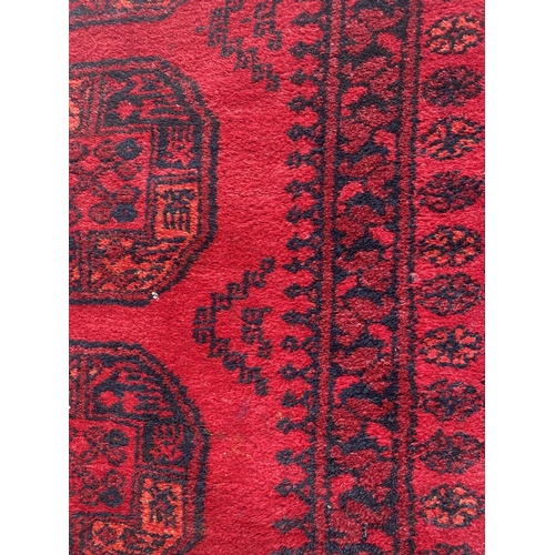 1991 - A LARGE RED PATTERNED AFGAN RUG