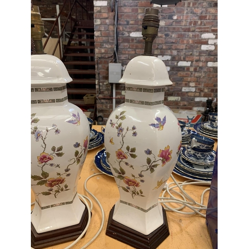 392 - A PAIR OF DECORATIVE CERAMIC TABLE LAMPS WITH A FLORAL DESIGN (A/F - HAIRLINE CRACK)