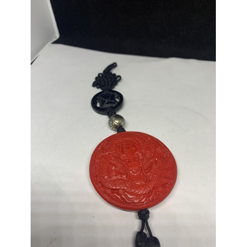 560 - AN ORIENTAL RED ROUND SEAL WITH BLACK TASSELS