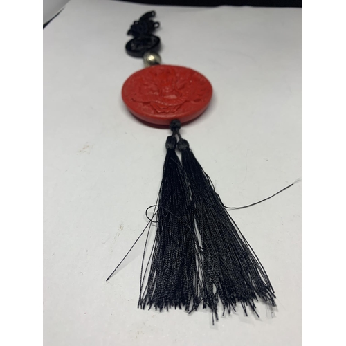 560 - AN ORIENTAL RED ROUND SEAL WITH BLACK TASSELS