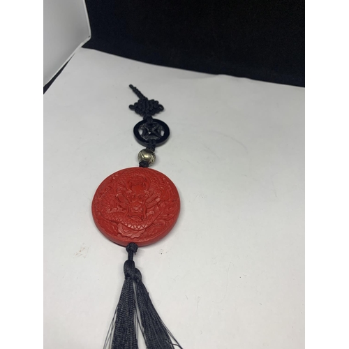 560 - AN ORIENTAL RED ROUND SEAL WITH BLACK TASSELS