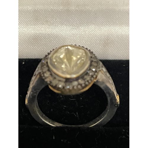 570 - A CONTINENTAL WHITE AND YELLOW METAL RING WITH CENTRE DIAMOND AND SMALLER SURROUNDING DIAMONDS WHICH... 